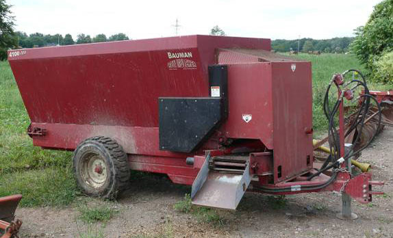 This mulching wagon, typically used in horticulture, is being used to deliver lower-cost fermented feeds to the herd in a quasi-TMR (forages layered inside), while the operators transition their feeding system toward full TMR infrastructure and the associated capital costs.