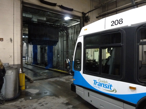 A dirty busy enters the Guelph Transit bus-wash facility