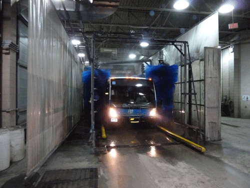 A bus goes through the Guelph Transit bus-wash facility