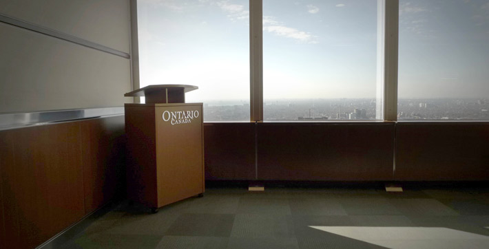 Photo du podium mobile en bois comportant le logo des gouvernements de l’Ontario et du Canada dans la Salle multimédia 