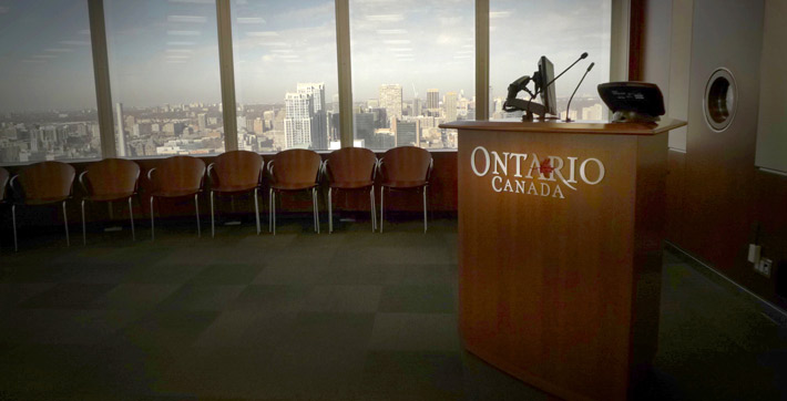 Photo des chaises à côté du podium et alignées le long des fenêtres de la Salle de conference