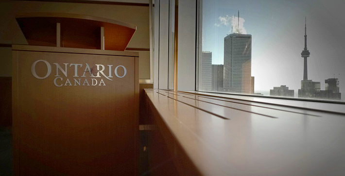 Photo du podium mobile en bois comportant le logo des gouvernements de l’Ontario et du Canada dans la Salle multimédia