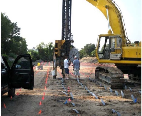Figure 3-2 is an image of wick drains being installed using stichers which are mounted to a backhoe.