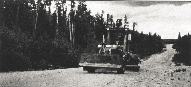 Black and white photo of a construction vehicle on a road.