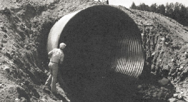 Black and white photo of a soil-covered culvert meant to show inadequate erosion protection.