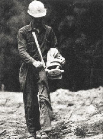 Black and white photo of a person engaged in the process of seeding.