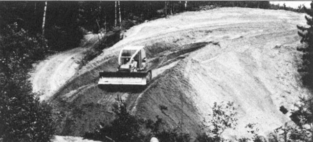Black and white photo of a vehicle on a sloping road.