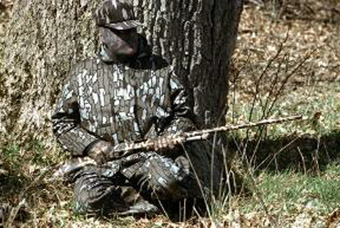 This hunter is well camouflage and positioned safely for hunting wild turkey.