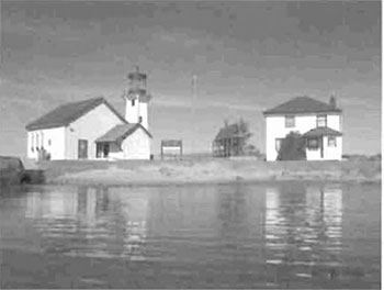 This photo shows two houses on the shore, Coast Guard Station located at the most southerly tip of Ile Parisienne.