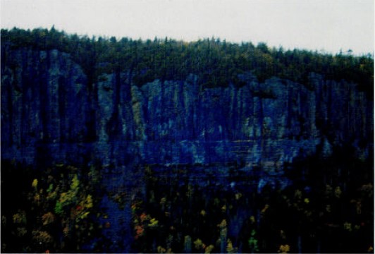 Picture of Kama Cliff face showing the diabase sills (vertical structure) over top of the red shales and mudstones (horizontal structure).
