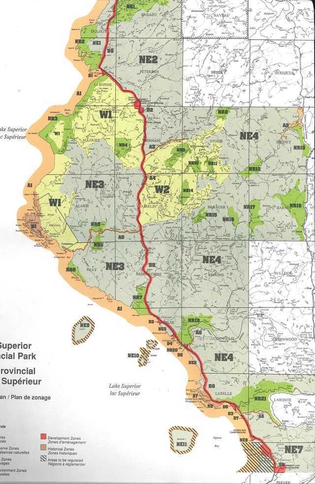 Colour zoning map of Lake Superior Provincial Park. Features cut-off legend including red areas for development zones, brown areas for historical zones and black striped areas for areas to be regulated.