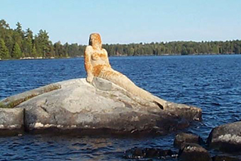 This is figure 4 photo of a mermaid statue on Rainy Lake