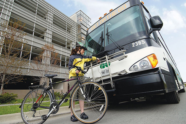 Photo of a cycler using the racks on the front of a Go Bus in the city.