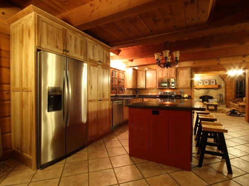 Cuisine rustique en érable créée à l’intérieur d’une maison en rondins par Premier Custom.