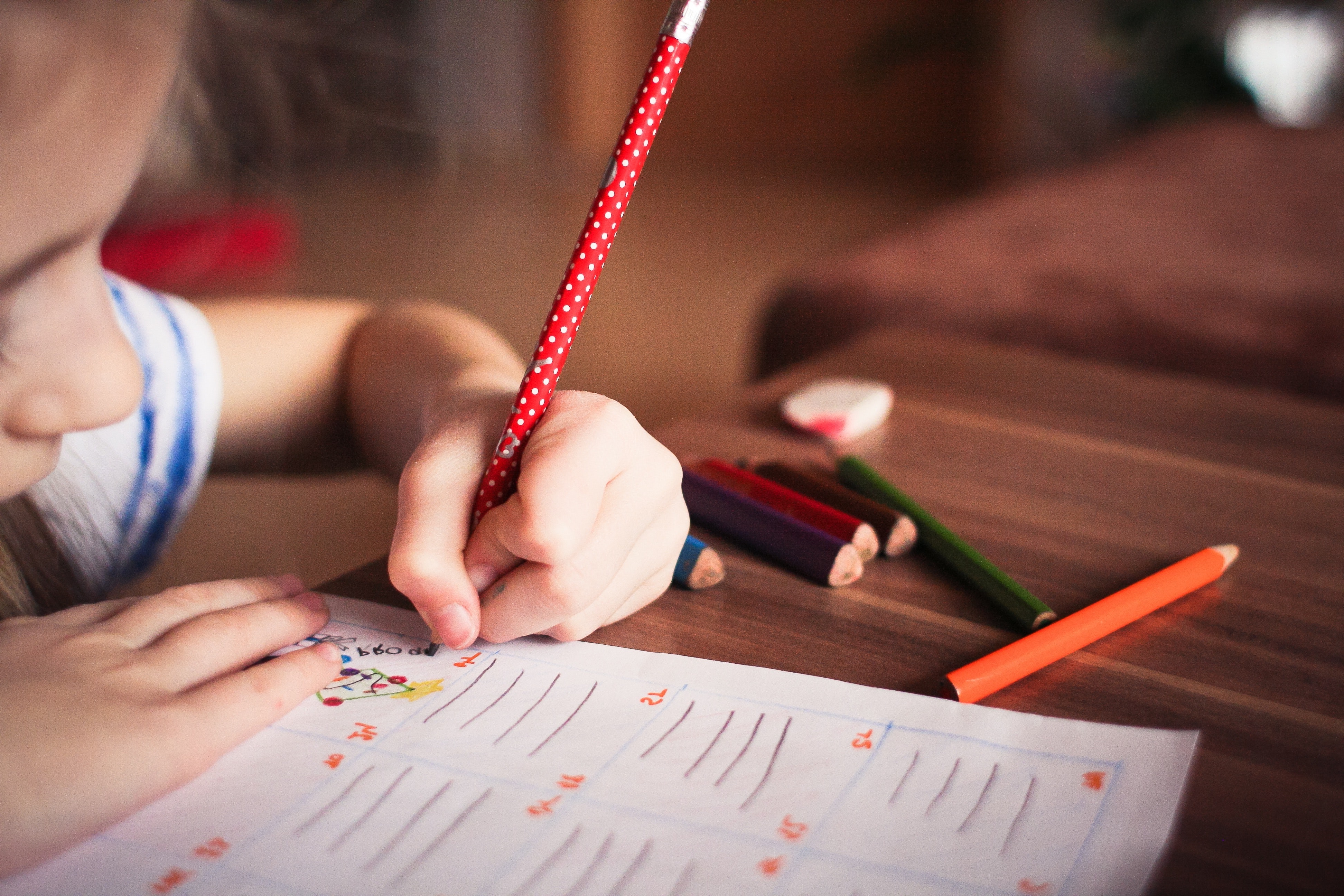 Un enfant écrit sur une feuille de papier
