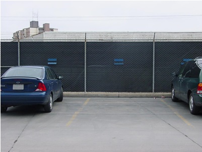 This picture shows lining that has been added to a facility’s fence, creating a barrier and minimizing fyurther off-site dispersion, and helps in accumulating fugitives at fence for further collection and clean-up.