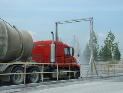 This picture shows a truck washing facility that is used to wash trucks, removing fugitives that may be on the trucks outer surface and therefore minimizing their release into the air.