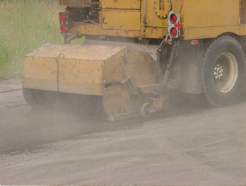 This figure shows a picture of a mechanical dry sweeping device being towed.