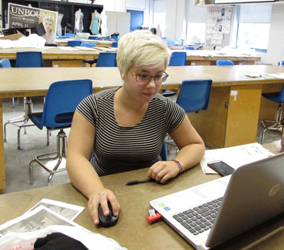 Photo of Louise Marchand, founder of Aura, working at a computer in her design studio.
