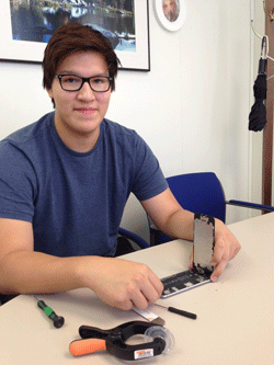 Photo of Waish Paypompee, founder of Lake of the Woods Phone Repair, repairing an iPhone.