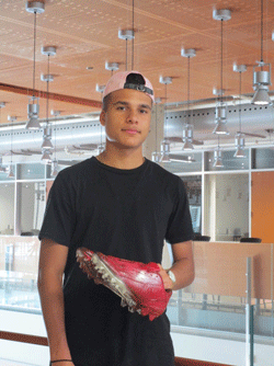 Photo of Zaheem Riberdy, founder of Kustom Kicks, holding a sample of his custom footwear.