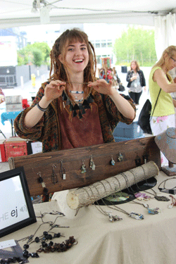 Photo of Emma Halenko, founder of Off the EJ, pictured here at her jewellery stand with some of her necklaces and earrings.