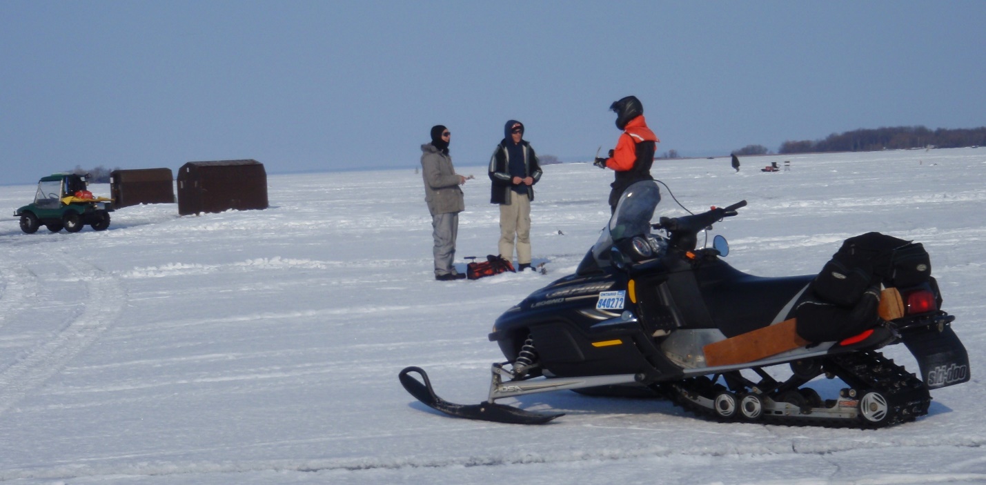 This image shows a Ministry employee speaking to anglers on a frozen Lake Simcoe