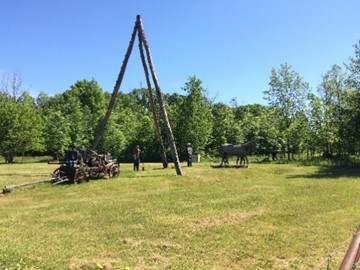A photograph showing a reconstruction of a wooden tripod about 10 metres high used for drilling in the 1800s in historical oil-producing areas of Lambton County.