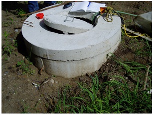 Figure 11-1 shows an open access lid on a dug well cover. The open lid is allowing slugs to enter the well (see Figure 11-2). The ground is not sloped away from the well to prevent ponding around the well. Even if the access lid was properly closed, surface water potentially containing pathogens and other foreign materials can still migrate through the unsealed opening (crack) between the access lid and cover and impair the well water.