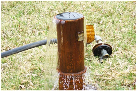 Figure 12-2 shows another flowing well discharging groundwater above the top of the well casing.