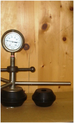 Figure 12-4 shows a flowing well pressure gauge device. It is made with an Ethylene Propylene Diene Monomer rubber packer which is sealed between two stainless steel plates at the bottom of the device. A steel rod with a tightening device and pressure gauge is installed to the packer.