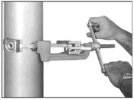 The diagram shows a strapping tool used to affix metal straps and a well tag to a well. See description in the above text.