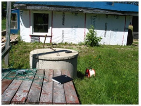 This is a typical dug well with circular concrete tiles supporting the sides of the well and the well cover.
