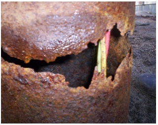 Figure 15-22 show the exterior of a drilled well with casing corroded to a point that a significant hole has formed through the well casing. The hole can also be seen here.