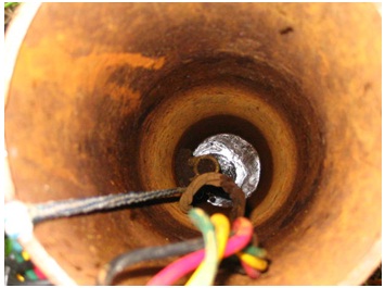 Figure 15-25 shows a pitless adapter located just above the well water level and extends through the left side of the drilled well casing.