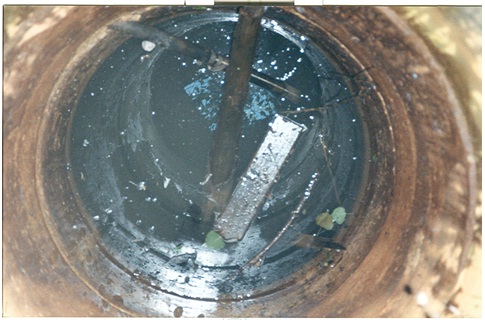 Figure 15-27 shows wood, pipe, sticks and leaves debris which may interfere with the plugging material’s (abandonment barrier’s) performance.