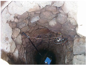 Inside view of older hand dug well with hand lain stone supporting the sides of the well.