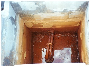 Inside view of an older drilled well housed below ground surface in a large well pit. In this case, contaminated water is entering the pit, moving through top of the well and contaminating the well water and groundwater.