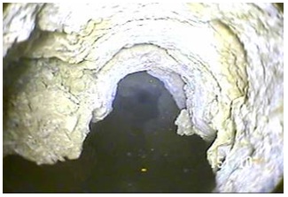 Figure 15-6 shows a still shot from a video of the open hole portion of a drilled well in bedrock. The hole has a large crevasse, which could not be observed from land surface. With this video information, the contractor can more accurately calculate the amount of plugging material needed and select the best method and equipment to seal the hole.