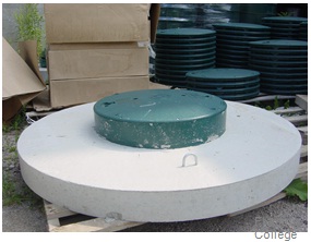 The image shows the green coloured solid watertight well cover sealed to the top of the concrete cover.