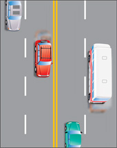 une route à quatre voies munie de doubles lignes jaunes continues pour les véhicules circulant en sens inverse et de lignes blanches discontinues pour les véhicules circulant dans la même direction
