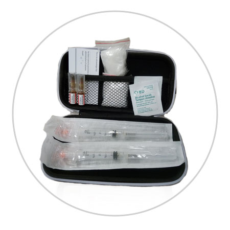 Picture of what is in an injectable naloxone kit: 1 hard case; 2 glass containers of naloxone; 2 syringes; 1 pair of gloves; 1 card that identifies the person who is trained to give the naloxone.