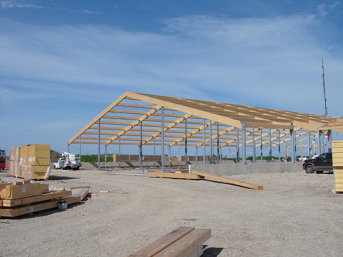 Frame of barn with posts and roof trusses.
