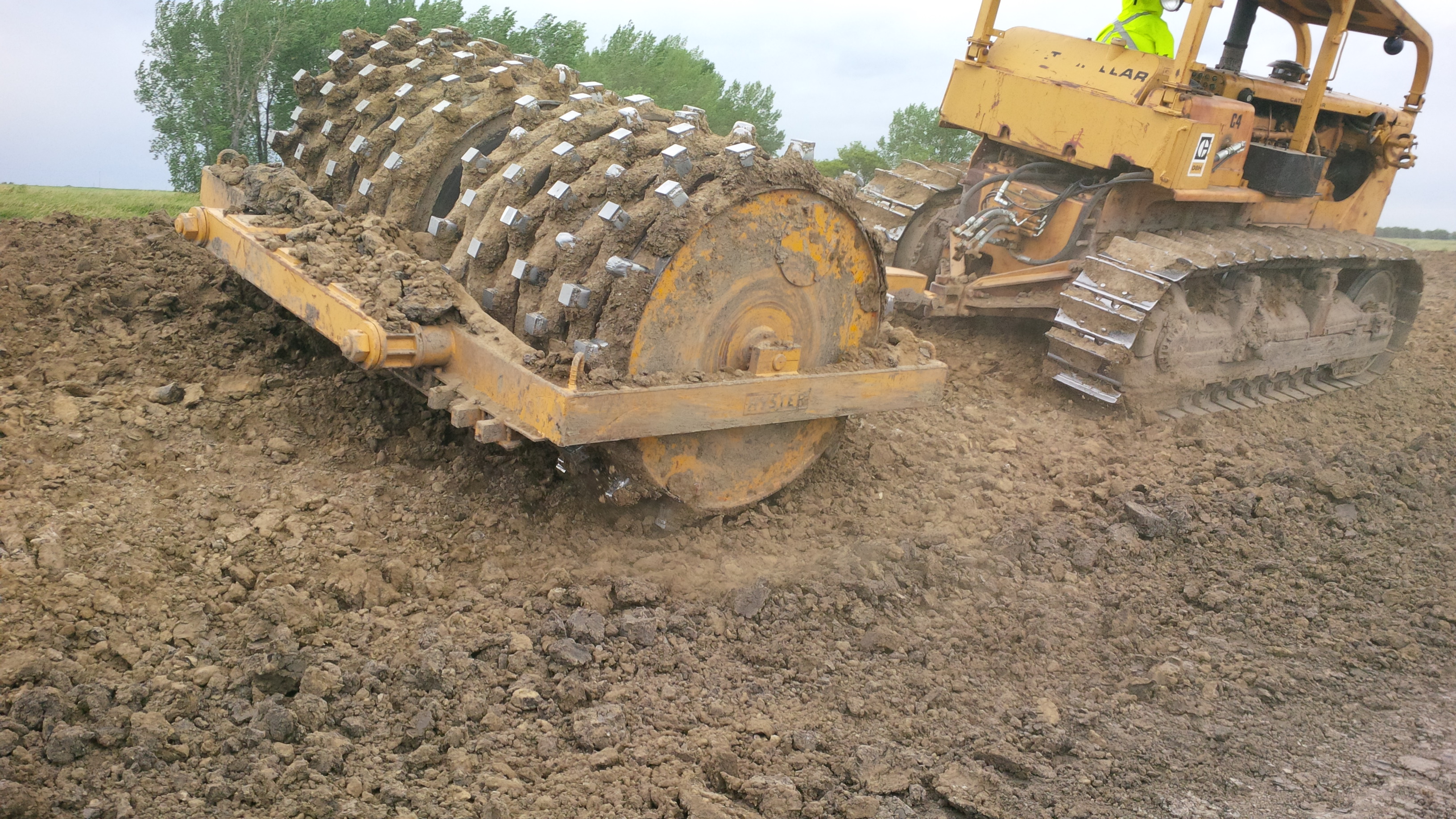Compacting soil using a sheepsfoot roller