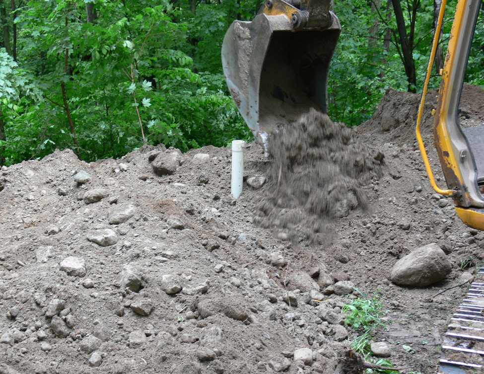 This is a picture of a white, round, steel disposal vessel sitting on top of the ground like a large casserole dish which is about 2 m in diameter by 2 m high.