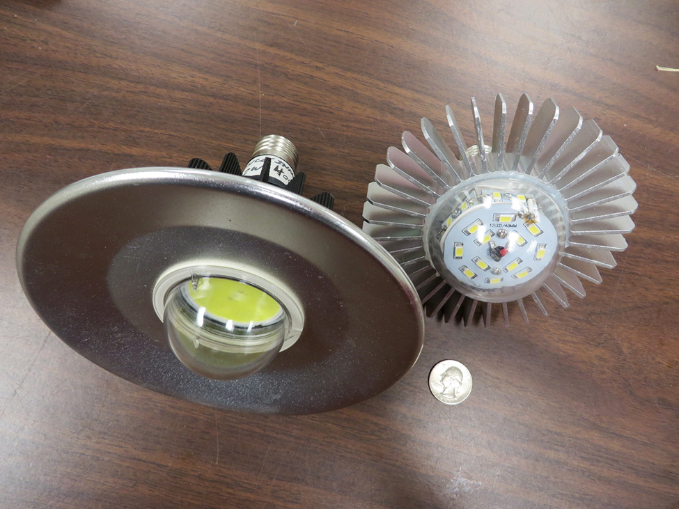 Photo shows two Edison style LED bulbs with external fins which conduct heat away from the diodes. There is a quarter in the photo to show the size of the bulbs.