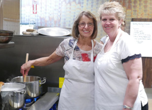 This is a picture of Marianne Katusin, Interim Director, Clinical Nutrition and Food Services and other foodservice staff in the kitchen at Oakville Trafalgar Memorial Hospital located in Oakville. The foodservices team is preparing meals using Ontario ingredients as part of their award-winning personalized meal delivery services for their hospital patients.