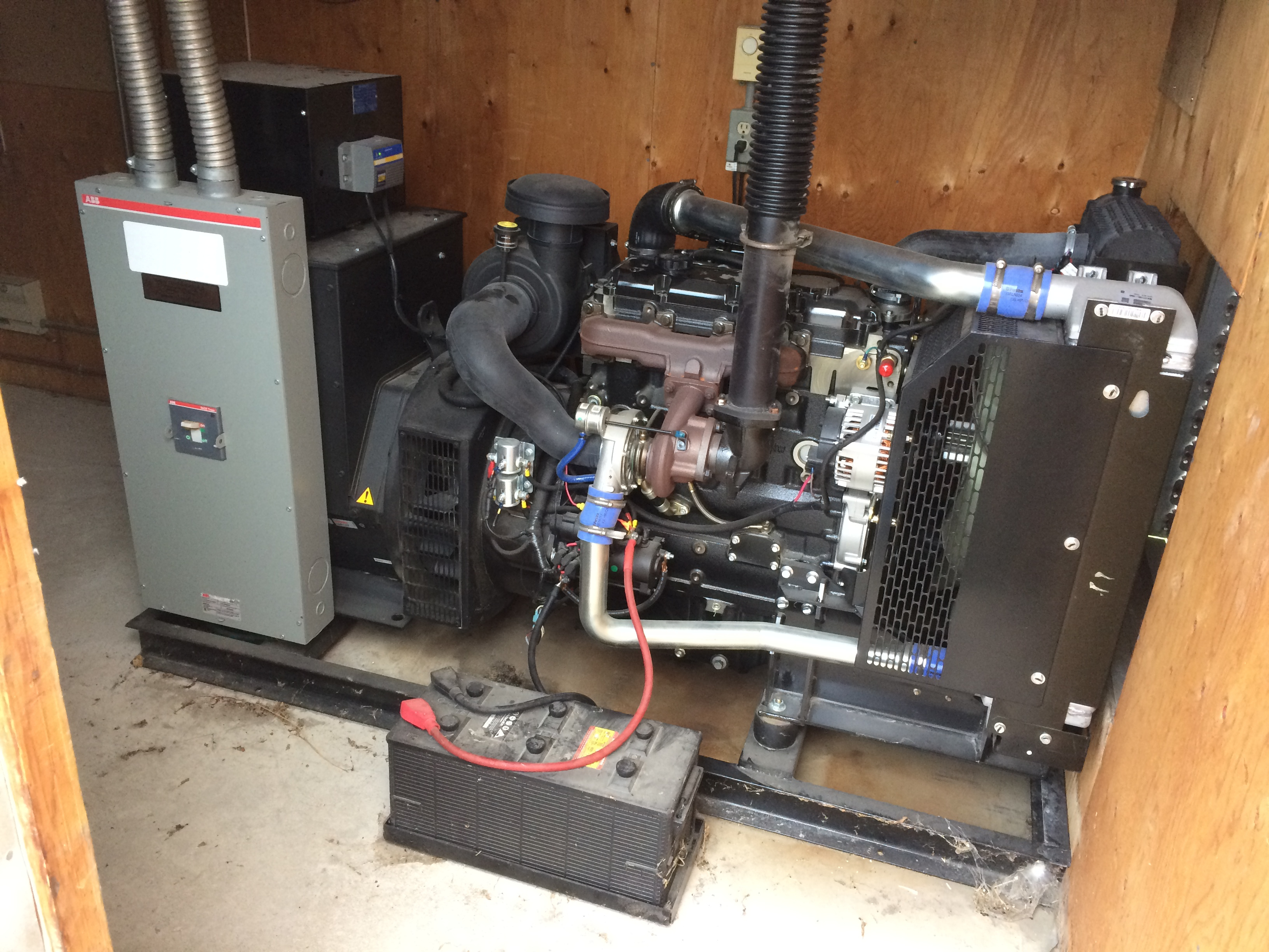 this photo shows a self-contained engine-driven generator, permanently installed inside a shed.