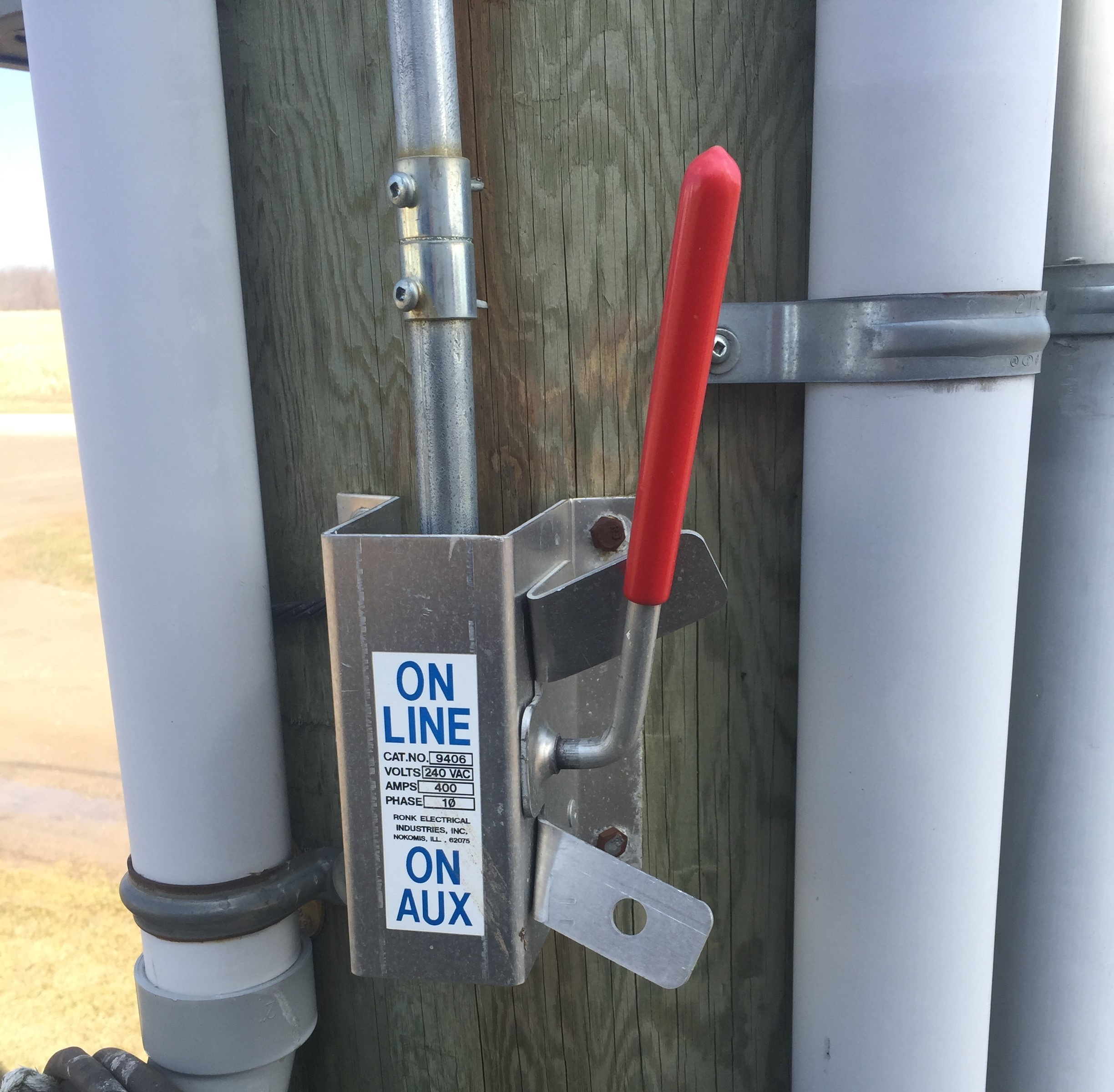 this photo shows a manual transfer switch installed on a utility pole, to enable the farmer to switch between utility power and generator power.