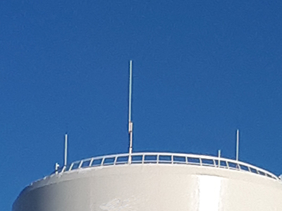 Structures like vertical poles mounted on top of a round water tower.